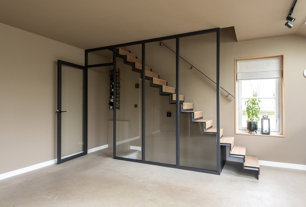 Moderne open trap en glazen scheidingswand in woonkamer.