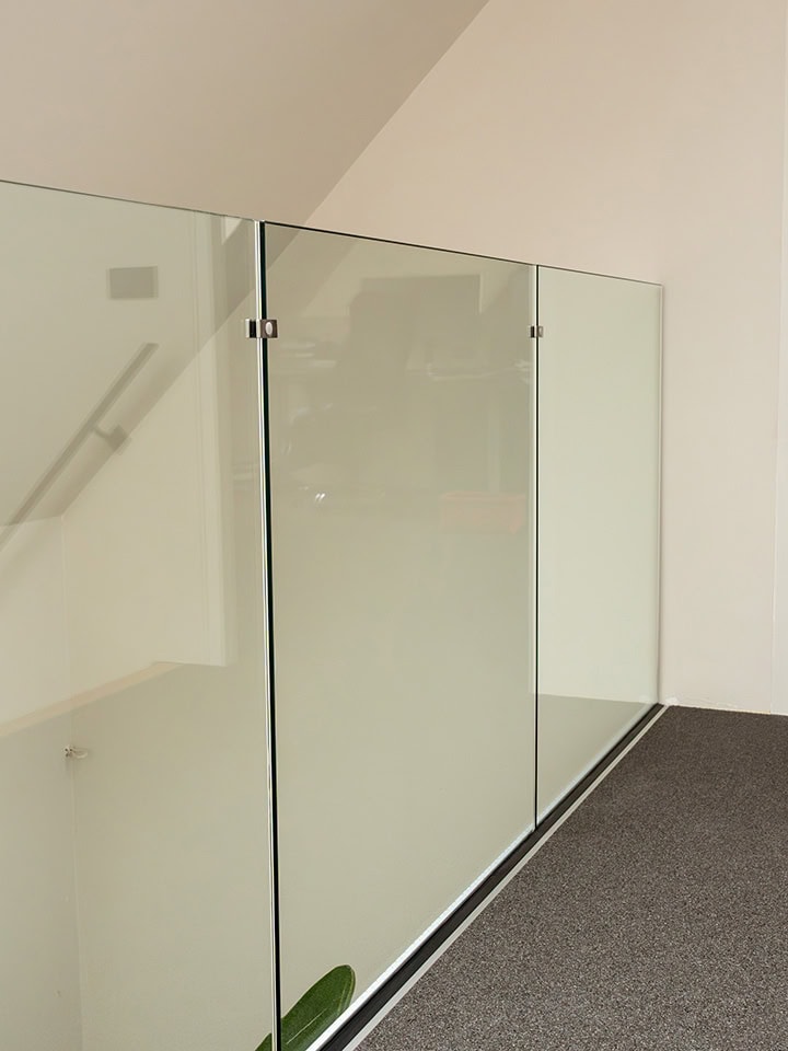 Glazen trapleuning en balustrade in modern interieur.