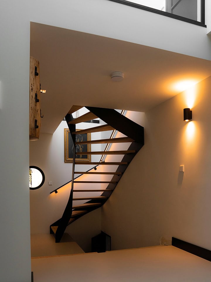 Moderne houten trap met zwarte rand in eigentijdse woning.