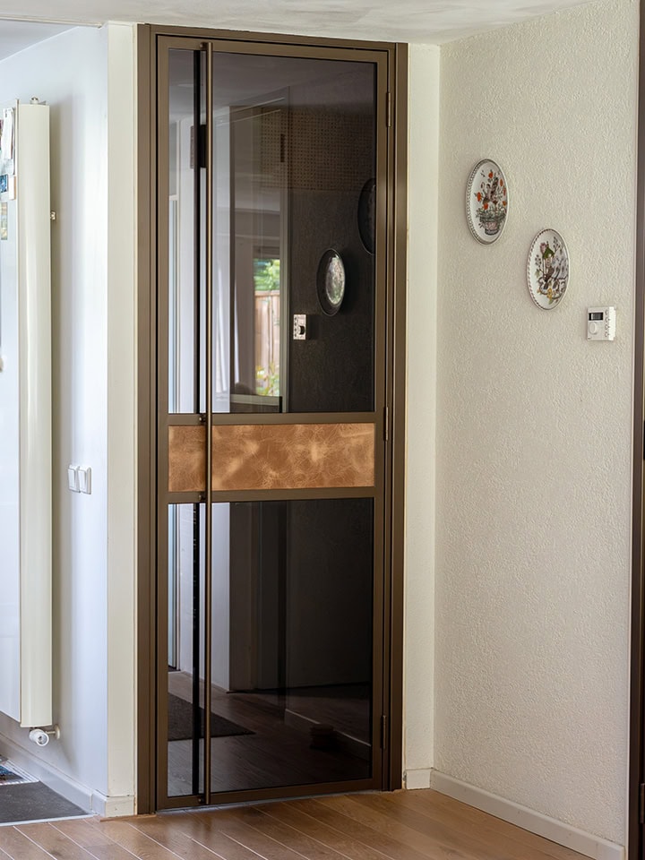 Bronzen scharnierdeur met leer in de deur